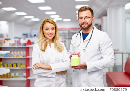 team of two pharmacists is showing medicine box presentation in pharmacy store team of two pharmacists is showing medicine box presentation in pharmacy store 70880379