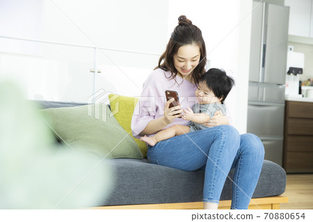 Baby and mom looking at smartphone 70880654