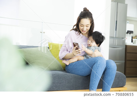 Baby and mom looking at smartphone 70880655