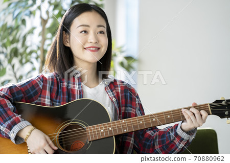 Young woman with a guitar Young woman with a guitar 70880962