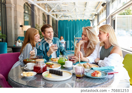 happy young caucasian friends gathering in cafe, sitting at table, chatting, talking happy young caucasian friends gathering in cafe, sitting at table, chatting, talking 70881253