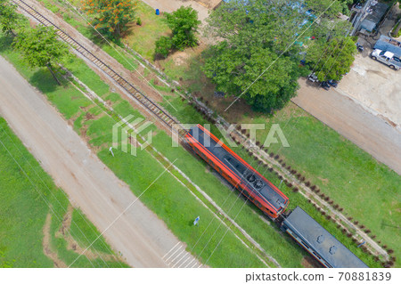 Aerial view of Thai local old classic train on railway on River Kwai Bridge in Kanchanaburi town, Thailand in public transportation concept. Aerial view of Thai local old classic train on railway on River Kwai Bridge in Kanchanaburi town, Thailand in public transportation concept. 70881839