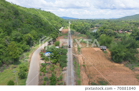 Aerial view of Thai local old classic train on railway on River Kwai Bridge in Kanchanaburi town, Thailand in public transportation concept. Aerial view of Thai local old classic train on railway on River Kwai Bridge in Kanchanaburi town, Thailand in public transportation concept. 70881840
