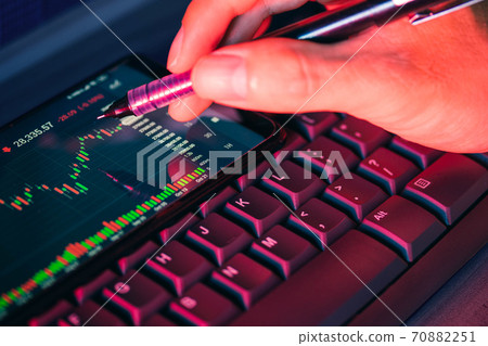Stock market chart screen on keyboard computer and hand hold pen, online investment concept 70882251
