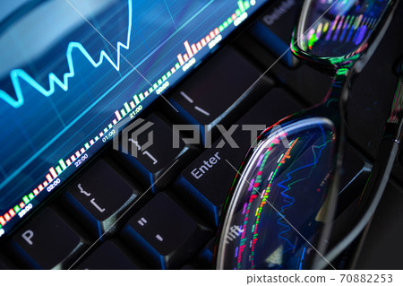 Stock market chart screen on keyboard computer and eyeglasses, online investment concept 70882253