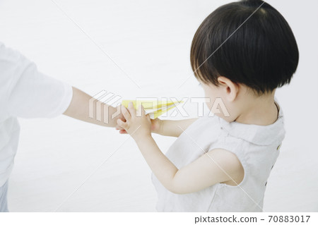 Toddler playing with paper airplane 70883017