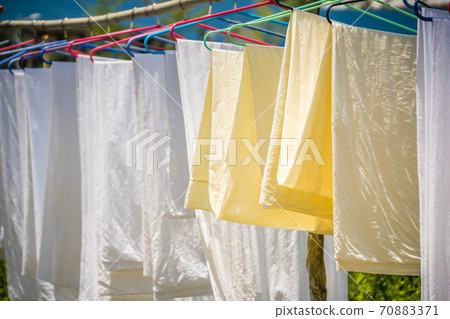 washed and clean bedsheets hanged to dry 70883371
