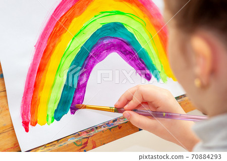 Child is drawing rainbow. 70884293