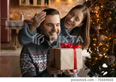 Happy couple exchange Christmas gifts at home 70884608