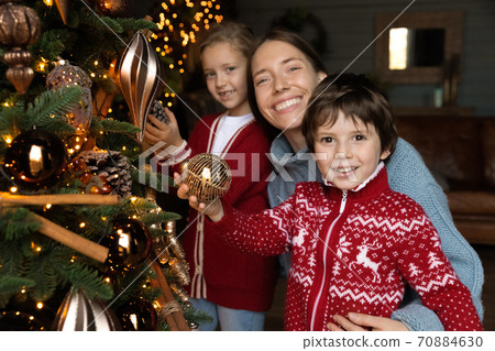 Portrait of happy mom and kids decorate Christmas tree 70884630