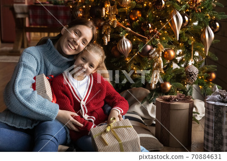 Portrait of loving mother and little daughter near Christmas tree 70884631