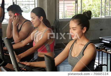 Group of people training with bicycle in gym. 70885114