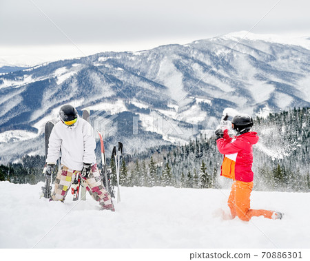 Young man and woman having fun at ski resort. 70886301
