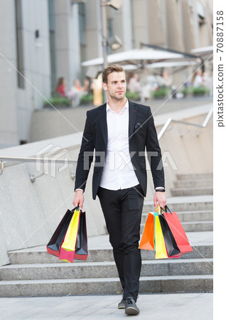 Guy carry bunch shopping bags. Profitable deals shopping on black friday Guy carry bunch shopping bags. Profitable deals shopping on black friday 70887158