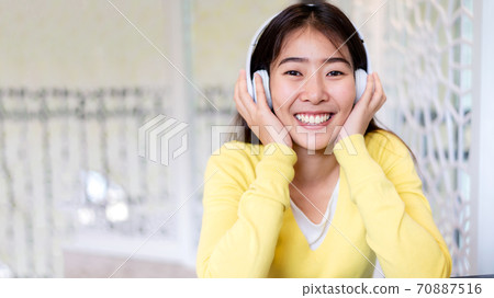 Inspired young asian woman listening the music at home. Inspired young asian woman listening the music at home. 70887516