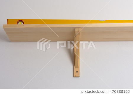 The process of attaching a wooden shelf to the wall The process of attaching a wooden shelf to the wall 70888193