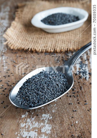 Poppy seeds in a spoon on rustic background 70889335