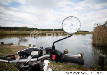 Blue sky reflected in the mirror of the off-road motorcycle Blue sky reflected in the mirror of the off-road motorcycle 70889793