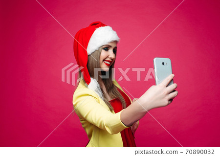 Surprised woman in santa hat making selfie over Surprised woman in santa hat making selfie over 70890032
