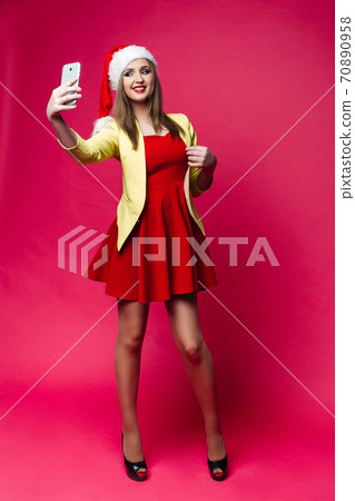 Surprised woman in santa hat making selfie over 70890958