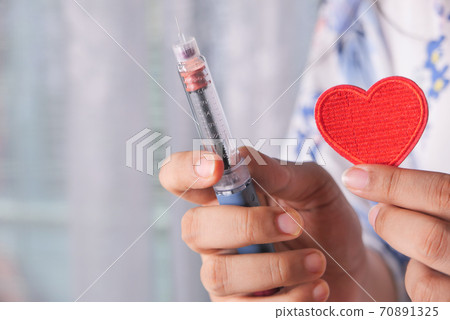 women hand holding Insulin pens and heart symbol with copy space  70891325