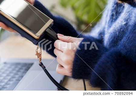 Woman charging a smartphone Woman charging a smartphone 70892094
