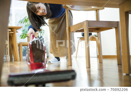 A woman cleaning a vacuum cleaner 70892206