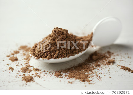 carob powder in a ceramic spoon carob powder in a ceramic spoon 70892971