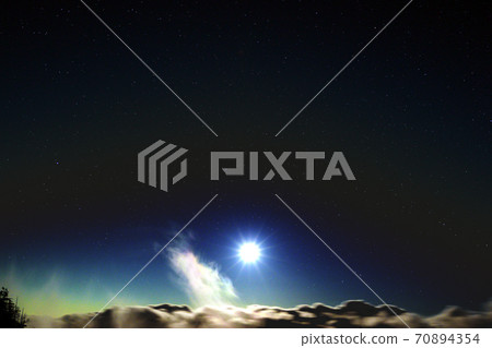 月亮和繁星點點的天空閃耀在雲層之上 70894354