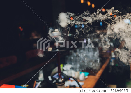 White ring of smoke on a black fabric background. Smoke spreads over the background. Vape culture. Conceptual image. 70894685