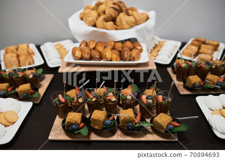 Canape, appetizers, on the table, buffet menu, European cuisine, shrimp, mini burger on a wooden background. 70894693