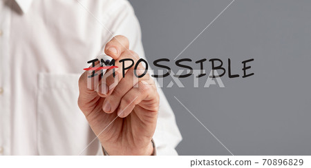 Businessman Crossing Out Word Impossible Making Everything Possible, Gray Background Businessman Crossing Out Word Impossible Making Everything Possible, Gray Background 70896829