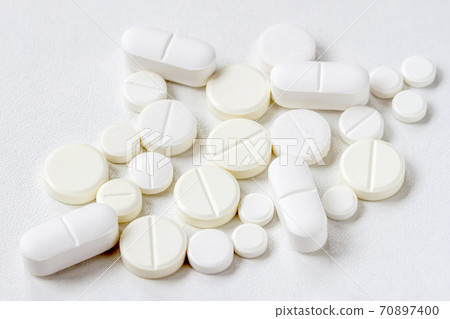 Medical background with light color pills, top view. Concept of health, pharmaceutical industry, medicine, treatment of illness. Medical background with light color pills, top view. Concept of health, pharmaceutical industry, medicine, treatment of illness. 70897400
