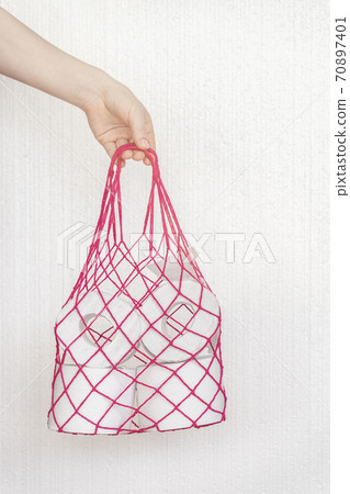 Girl's hand holds a bag. Zero waste grocery shopping concept and problem with consumer essential goods, virus, hygiene, health and antipanic Girl's hand holds a bag. Zero waste grocery shopping concept and problem with consumer essential goods, virus, hygiene, health and antipanic 70897401