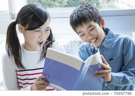 Elementary school student reading a book Elementary school student reading a book 70897786