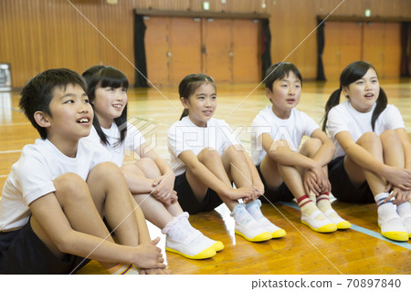 Elementary school students sitting on the floor of the gymnasium 70897840