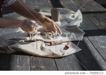 Close up picture of female ceramic artist arms in clay after making pottery. 70899112