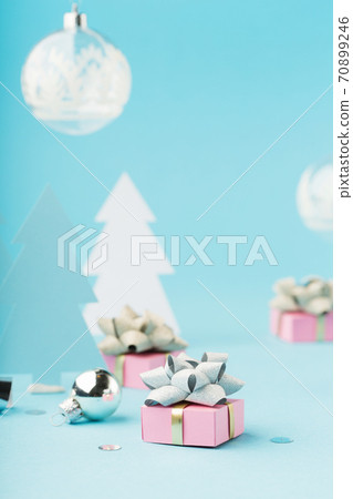 Christmas holiday card with pink Xmas gifts, silver decorations, mirror disco balls on light blue background. 70899246