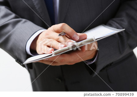 Male hand holding silver pen Male hand holding silver pen 70899439