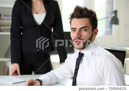 Handsome smiling businessman in suit portrait at workplace Handsome smiling businessman in suit portrait at workplace 70899829