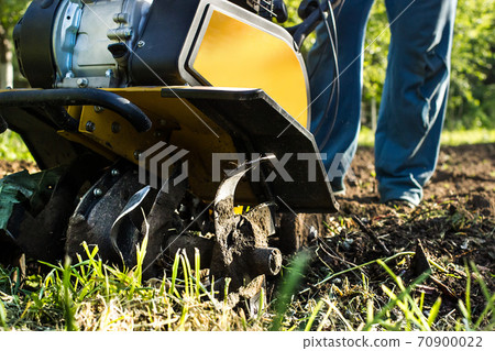 Grass and plowed soil nuggets during motor cultivator spring garden or farm work Grass and plowed soil nuggets during motor cultivator spring garden or farm work 70900022