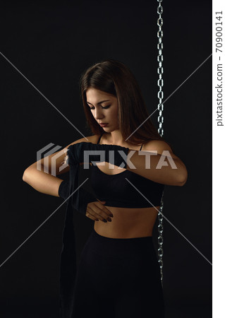 Woman boxer wearing strap on wrist Woman boxer wearing strap on wrist 70900141