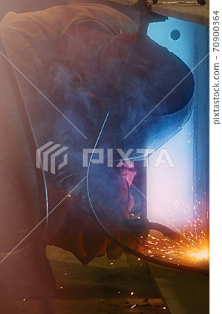 Welder uses welding machine to make sparks during manufacture of metal construction Welder uses welding machine to make sparks during manufacture of metal construction 70900364