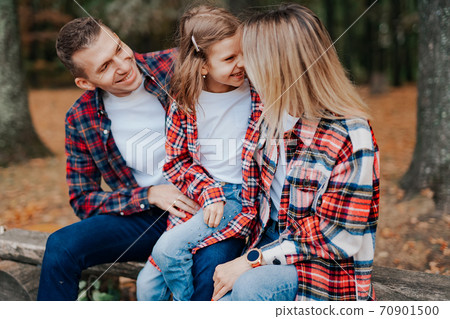 photo of a wonderful family in the autumn forest on a bench photo of a wonderful family in the autumn forest on a bench 70901500