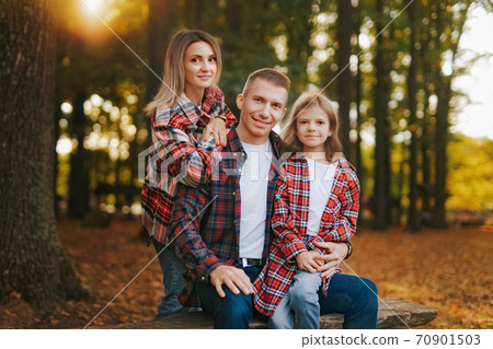 photo of a wonderful family in the autumn forest on a bench photo of a wonderful family in the autumn forest on a bench 70901503