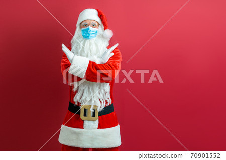Santa Claus in a medical mask on a red background Santa Claus in a medical mask on a red background 70901552