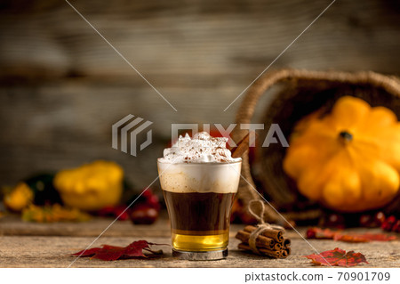 Pumpkin spice latte with cinamon powder and delicious flavours on the old textured wood table with colorful dry leaves and pumpkins Pumpkin spice latte with cinamon powder and delicious flavours on the old textured wood table with colorful dry leaves and pumpkins 70901709