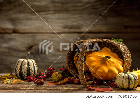 Autumn still life concept with a corf full of chestnuts, pumpkins and colorful dry leaves Autumn still life concept with a corf full of chestnuts, pumpkins and colorful dry leaves 70901710