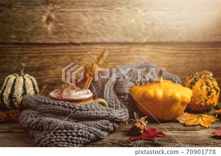 Autumn concept, still life of pumpkin spice latte with whipped milk cream and cinamon. Colorful pumpkins and dry leaves. Old natural wood backround Autumn concept, still life of pumpkin spice latte with whipped milk cream and cinamon. Colorful pumpkins and dry leaves. Old natural wood backround 70901778