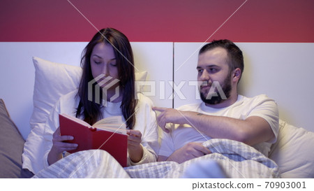 Husband invites his wife to have sex. Family life. A married couple lies in bed 70903001